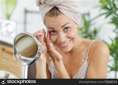 a young woman plucking eyebrows