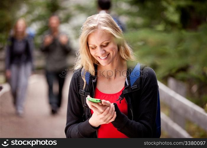 A young woman reading a friendly text while outdoors