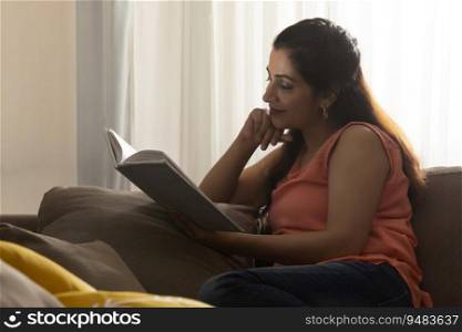 A YOUNG WOMAN READING BOOK WITH CONCENTRATION