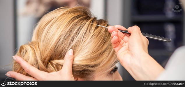 A young woman receiving her hair done in a beauty salon. Woman receiving her hair done