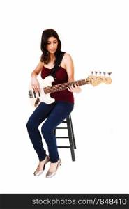 A young woman sitting on a chair, playing her guitar, isolated on whitebackground.