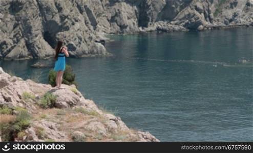 a young woman standing on the edge of a cliff near the sea Balaklava, Crimea, Ukraine