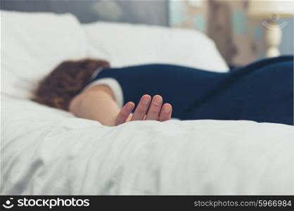 A young woman wearing a dress is passed out on a bed