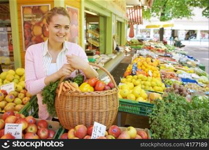 a young woman while shopping at a market. fresh vegetables and fruits in season