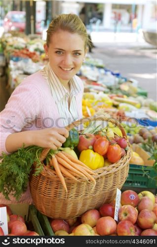 a young woman while shopping at a market. fresh vegetables and fruits in season