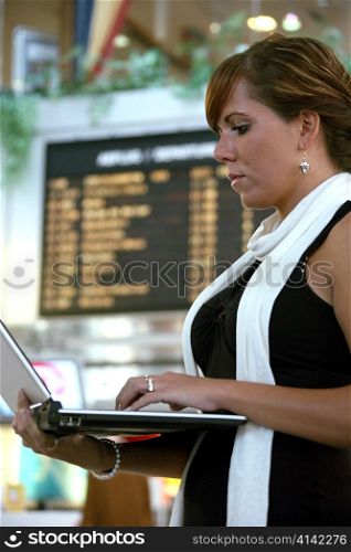 a young woman with a computer at an airport