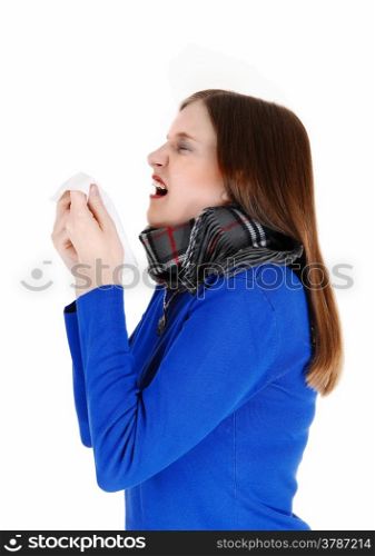 A young woman with a heavy scarf around her neck holding a tissue andsneezing, isolated for white background.
