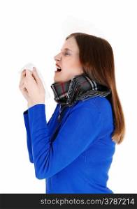 A young woman with a heavy scarf around her neck holding a tissue andsneezing, isolated for white background.