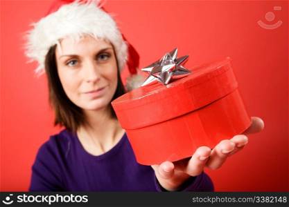 A young woman with a present isolated on red - shallow depth of field with the focus on the present box.
