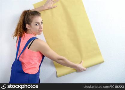 a young woman with a roll of yellow wallpaper