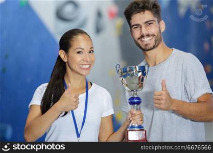 a young woman with a trophy and a smiling guy