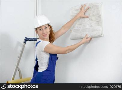 a young woman with roll of wallpaper