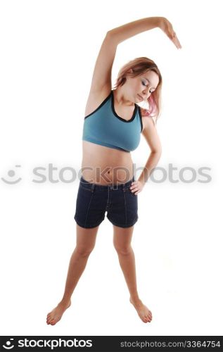 A young women in a blue sports bra and shorts standing on barefeet and doing some gymnastic, for white background.
