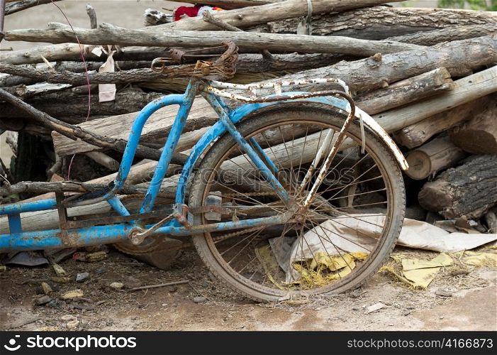 Abandoned bicycle leaning against a heap of logs, Sacred Valley, Cusco Region, Peru