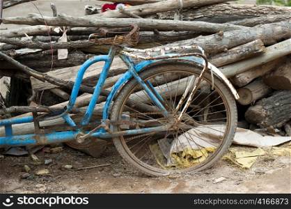 Abandoned bicycle leaning against a heap of logs, Sacred Valley, Cusco Region, Peru