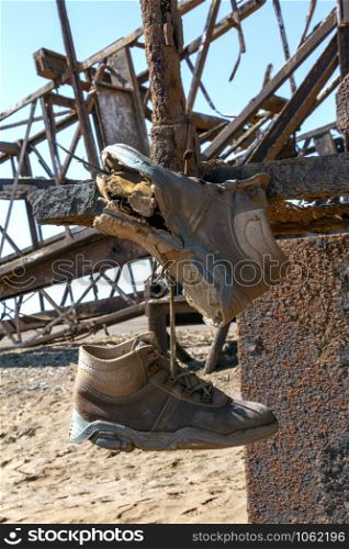 Abandoned Engineering - Old boots and rusting infrastructure of an old oil rig on the Skeleton Coast in Namibia, Africa.