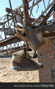 Abandoned Engineering - Old boots and rusting infrastructure of an old oil rig on the Skeleton Coast in Namibia, Africa.