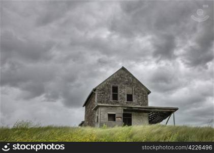 Abandoned Farm with storm clouds in the Canadian Prairie