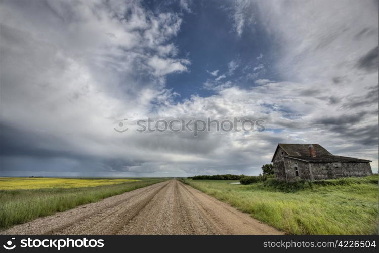 Abandoned Farm with storm clouds in the Canadian Prairie