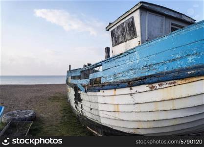 Abandoned fishing boat on beach during lovely Summer morning