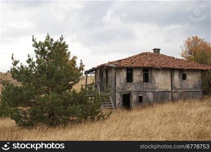 Abandoned house in the mountain on a cloudy autumn day