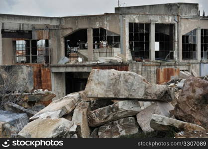 Abandoned marble processing factory and pile of granite slates. Industrial ruins.