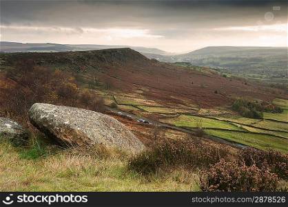 Abandoned millstones on Curbar Edge in Peak District National Park with Froggatt&acute;s Edge in background
