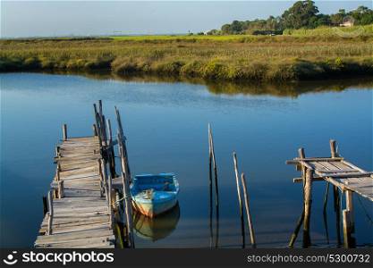 abandoned old fishing boat doked in calm water in comporta, alentejo Portugal.