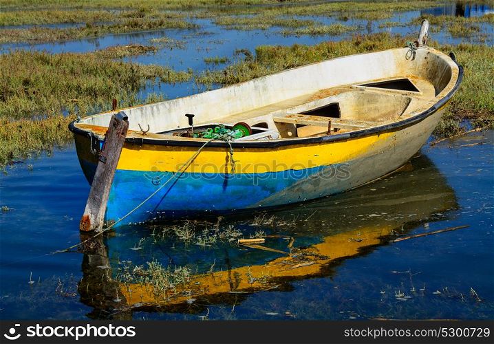 abandoned old fishing boat in calm water in comporta, alentejo Portugal.