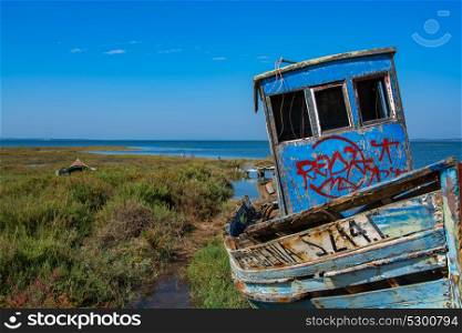 abandoned old fishing boat in calm water on comporta, alentejo Portugal.