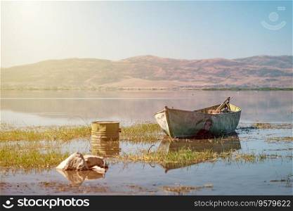 Abandoned old fishing boat in the lake that started to dry up and recede due to global warming.