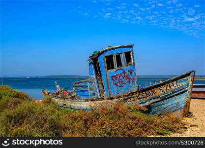 abandoned old fishing boat lying near the water in comporta, alentejo Portugal.