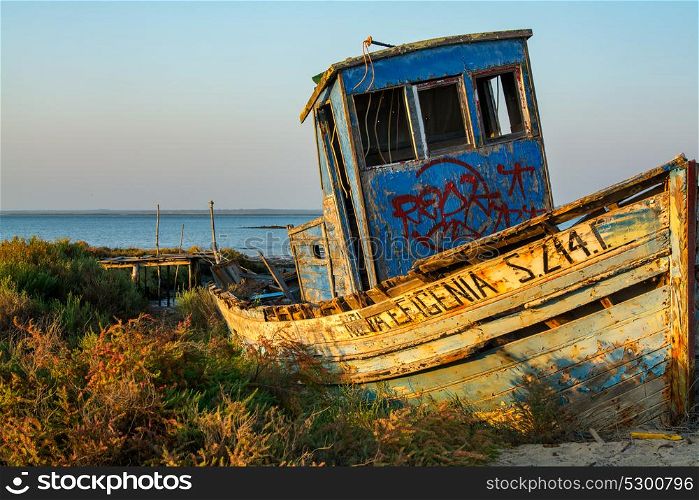 abandoned old fishing boat lying near the water in comporta, alentejo Portugal.