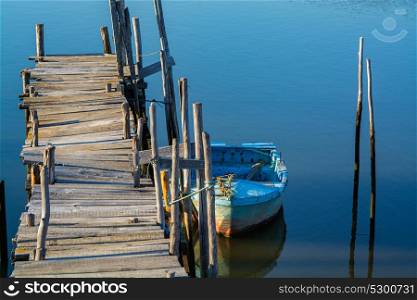 abandoned old fishing docked in calm water in comporta, alentejo Portugal.