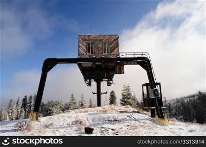 Abandoned Ski Lift. An old abandoned ski lift at the top of a mountain in the California Sierra Nevada mountains with a light covering of new snow