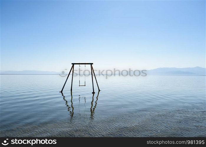 Abandoned swing in the water at Bombay beach, Salton Sea, California