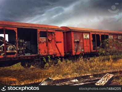 Abandoned train composition on dramatic clouds background