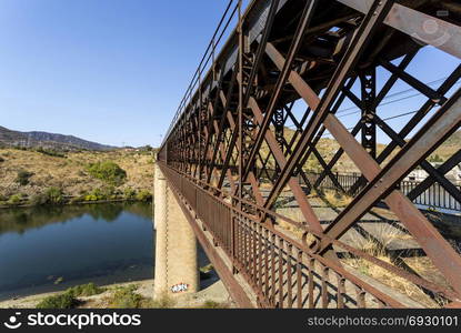 Abandoned truss road-rail bridge with the rail track above the roadway crossing the Douro River in Pocinho, Douro region, Portugal