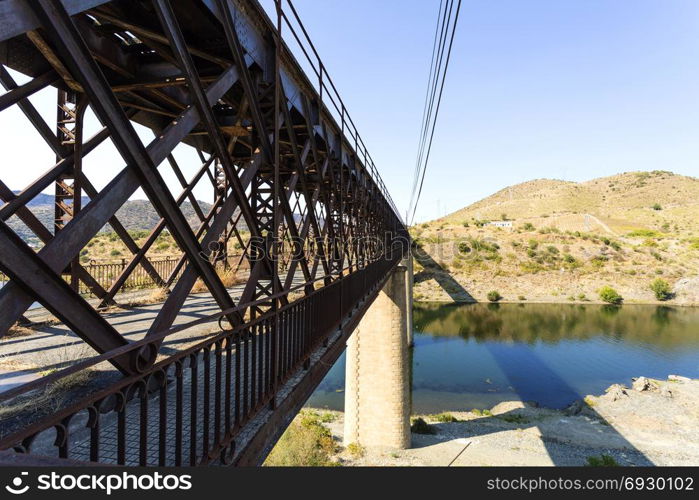 Abandoned truss road-rail bridge with the rail track above the roadway crossing the Douro River in Pocinho, Douro region, Portugal