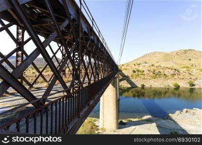 Abandoned truss road-rail bridge with the rail track above the roadway crossing the Douro River in Pocinho, Douro region, Portugal