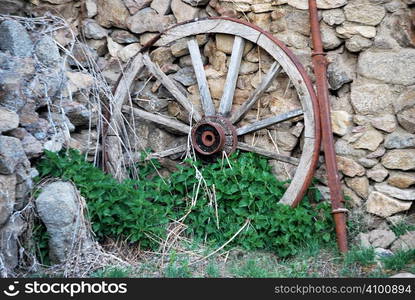 Abandoned wooden cartwheel on the wall. Vintage concept