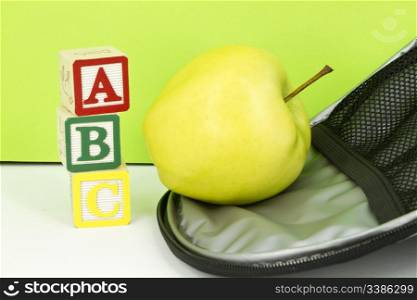 ABC blocks, golden apple, and interior of lunchbag reflect on successful education&rsquo;s need for healthy lunches