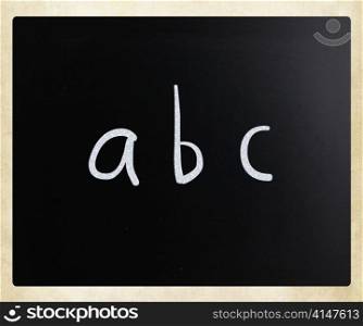 ""abc" handwritten with white chalk on a blackboard"