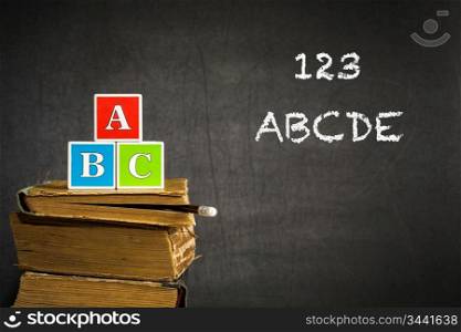 ABC on old books in class against blackboard. School concept