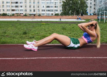 Abdominal muscles exercises. A young beauty athletic woman in sportswear doing exercises for abs