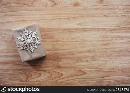 Above brown gift and christmas decoration on wooden background