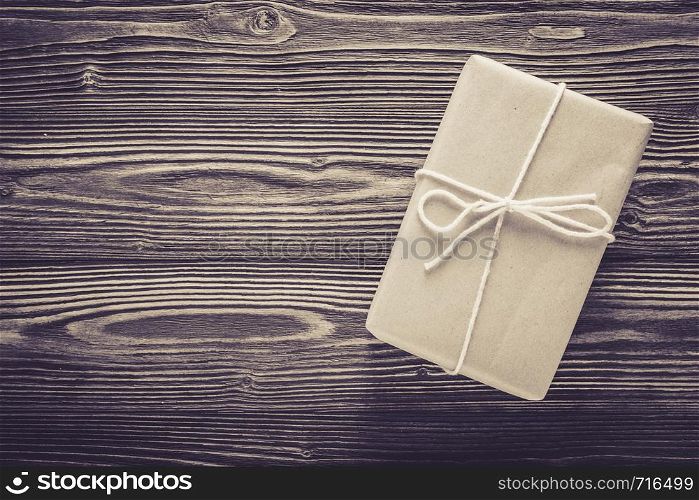 Above package gift box and rope on wood table texture background with birthday copy space, top view, holiday celebration concept.