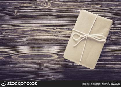 Above package gift box and rope on wood table texture background with birthday copy space, top view, holiday celebration concept.
