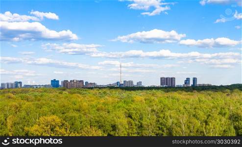 above view of green forest near city in summer. above view of green forest of Timiryazevsky park in Moscow city in sunny summer day