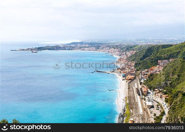 above view of Ionian Sea coastline and Giardini Naxos town from Taormina city, Sicily, Italy in spring
